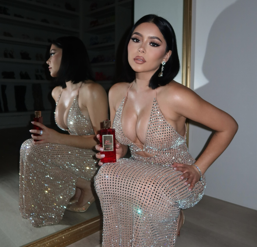Daisy Marquez posing in a shimmering, floor-length sequin dress as she showcases her signature scent, Scarlet Eau de Parfum by Bella Perversa.