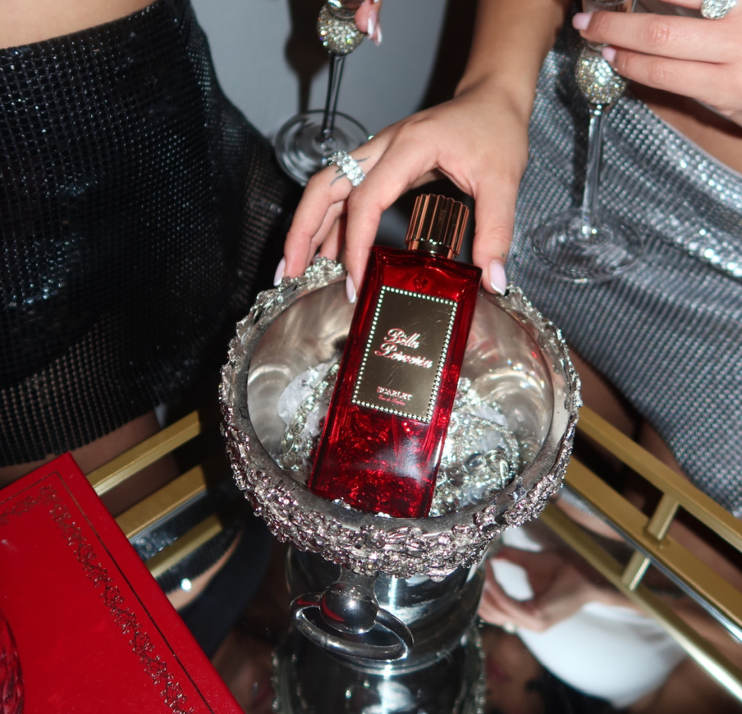 Scarlet by Bella Perversa rests elegantly in a silver chalice, surrounded by scattered diamonds and glimmering glitter, casting a shimmer.