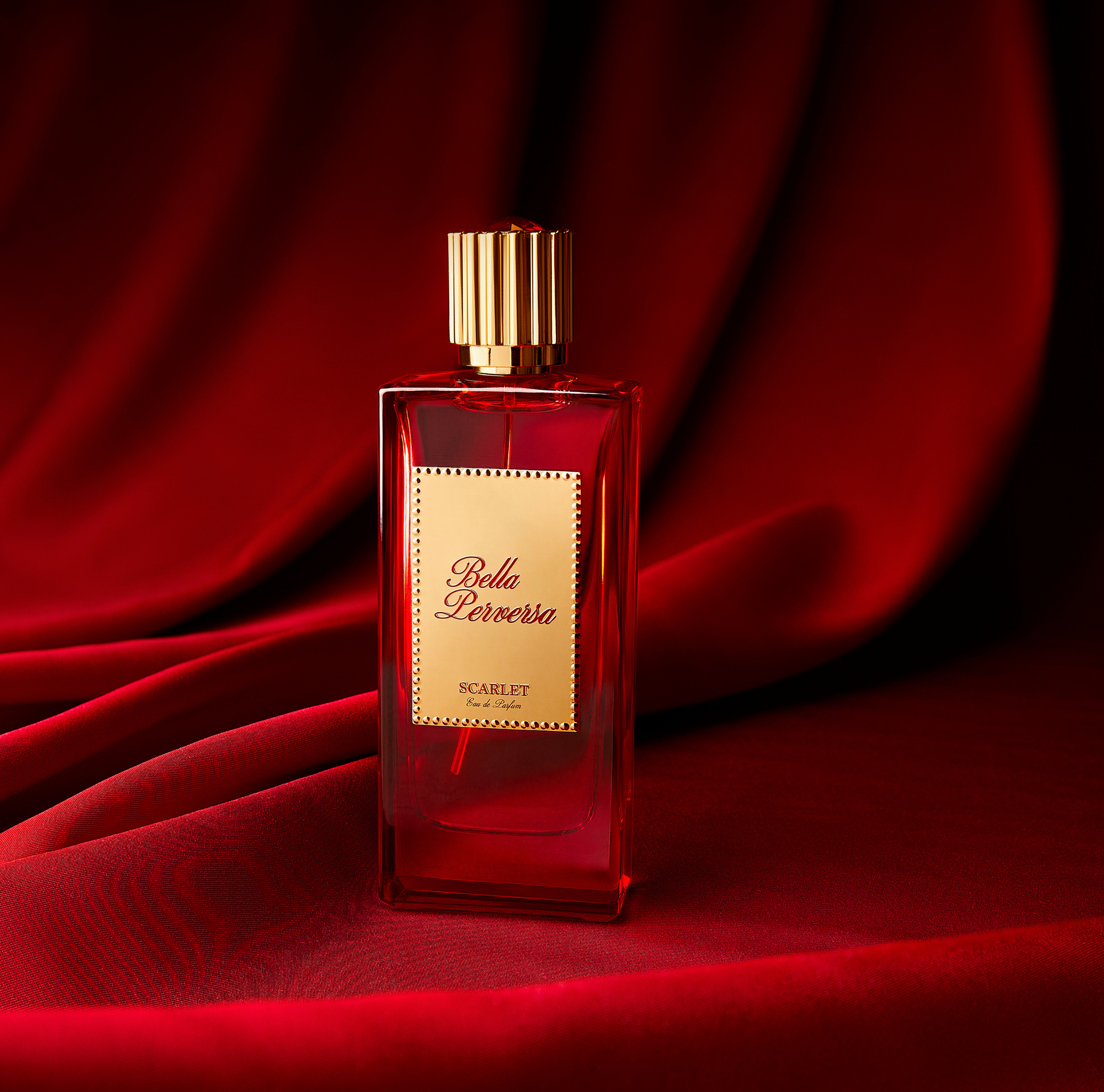 Scarlet Eau de Parfum by Bella Perversa, created by influencer Daisy Marquez, 2.5 fl oz, showcased against a rich red textured fabric background.