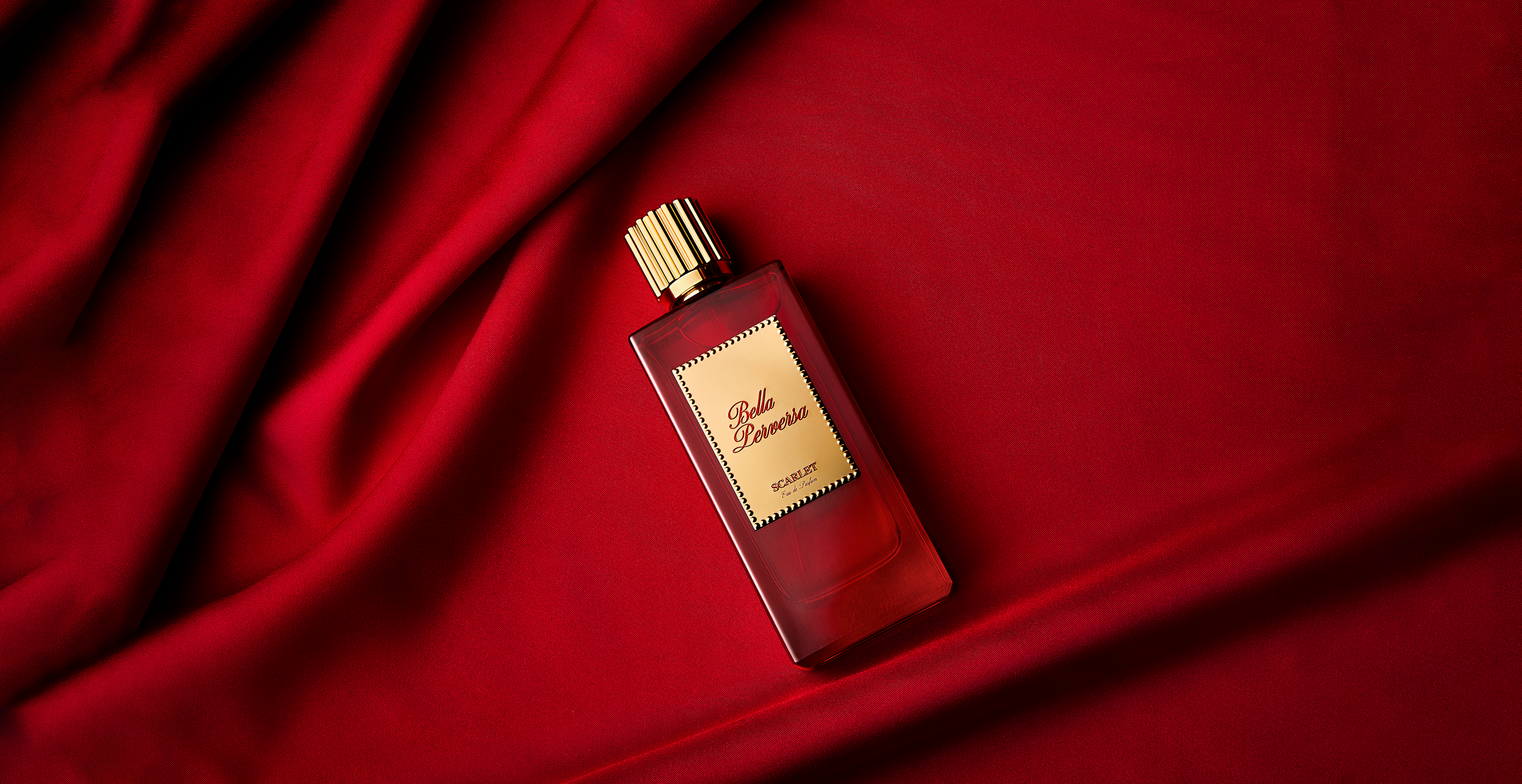 Scarlet Eau de Parfum 2.5 fl oz resting against a textured red background.