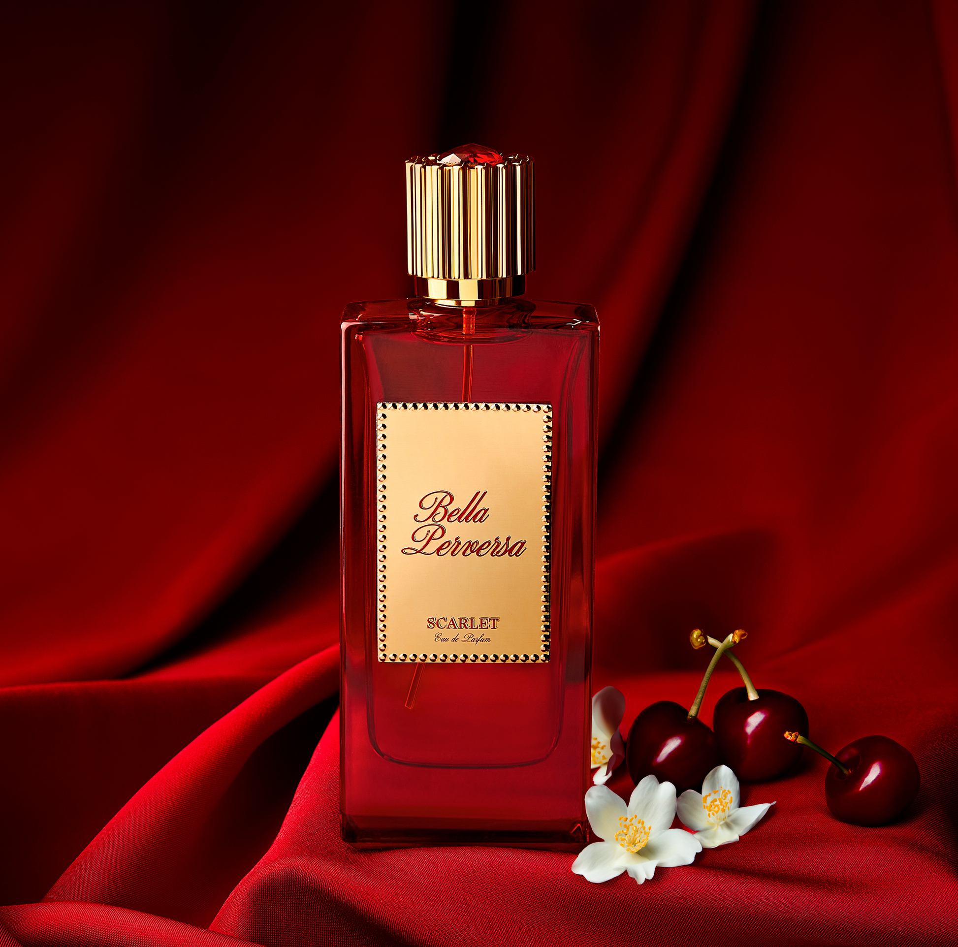 Scarlet Eau de Parfum 2.5 fl oz displayed with two of its key notes bing cherries and jasmine flowers.